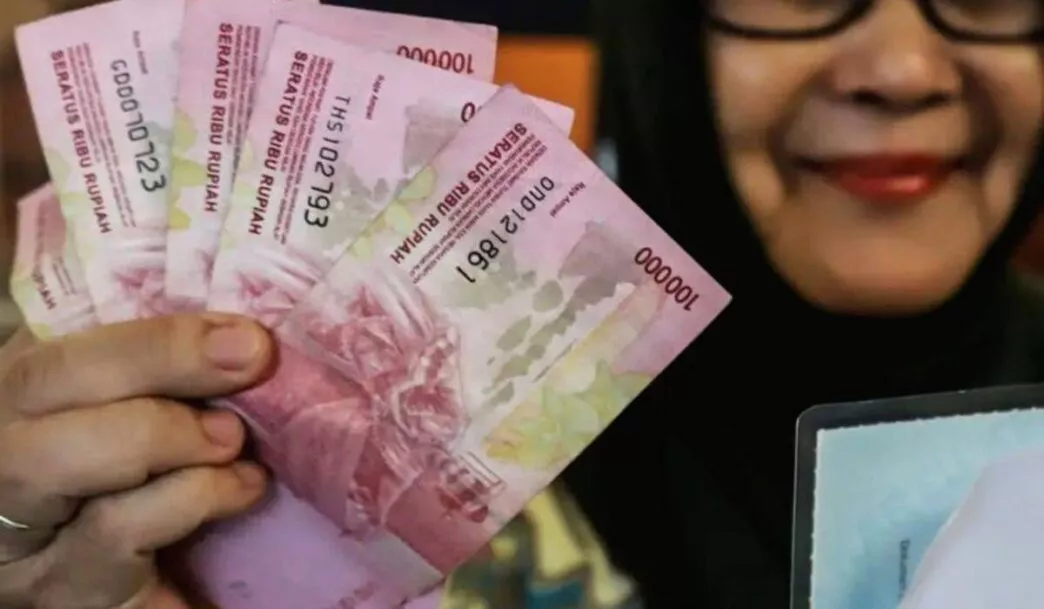 Smartphone modern yang dipajang di display dengan latar belakang teknologi, menyiratkan sistem penyaluran bansos yang sudah terdigitalisasi.