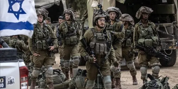 Sekelompok tentara Militer Israel berhelm dan seragam tempur berdiri berkelompok dengan bendera Israel, menunjukkan pasukan bersenjata.