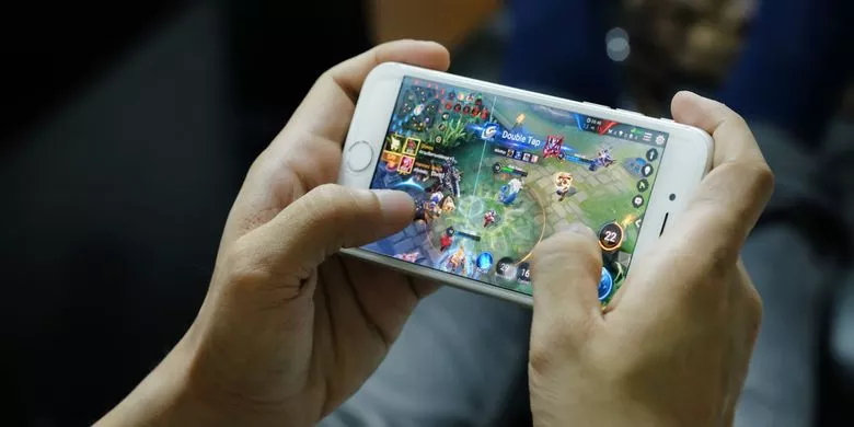 Seseorang memegang smartphone layar lebar yang menampilkan wallpaper bunga berwarna-warni dengan bezel tipis.