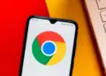 Smartphone dengan latar belakang teknologi, menyimbolkan masalah keamanan data atau konflik software antara Apple dan Google Chrome.