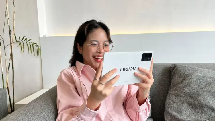 Seorang gamer tersenyum gembira saat menggunakan tablet Lenovo Legion Tab Gen 3 berwarna putih, ditenagai Snapdragon 8 Gen 3 untuk pengalaman bermain game yang lancar.