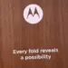Teaser resmi HP lipat buku Motorola terbaru berupa undangan kayu dengan tulisan Every fold reveals a possibility untuk peluncuran Januari 2026