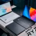 Setup studio menampilkan rekomendasi laptop AMD Ryzen terbaik 2025, termasuk Asus Zenbook putih dan Razer Blade hitam dengan logo AMD Ryzen.