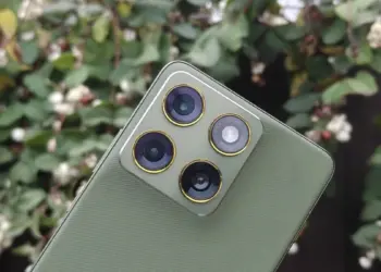 Close-up desain modul kamera belakang Motorola Signature berwarna hijau dengan tekstur premium, menampilkan lensa utama 50MP OIS dan aksen emas.