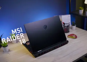 Review MSI Raider 18 HX AI tampak belakang di atas meja kerja, menampilkan desain premium laptop gaming flagship dengan logo naga MSI.