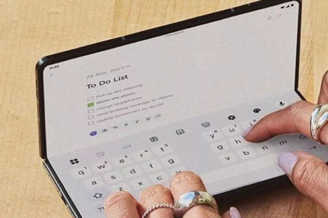 Seseorang sedang mengetik di layar besar Motorola Razr Fold yang terbuka penuh, menampilkan fitur produktivitas di CES 2026.