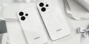 Dua unit smartphone OPPO Reno15 warna Aurora White dengan desain bodi glossy dan modul kamera boba yang elegan di atas meja dekoratif.