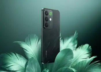 Realme C85 5G warna hijau gelap berdiri di atas dekorasi daun, menunjukkan sertifikasi militer dan bodi tangguh.