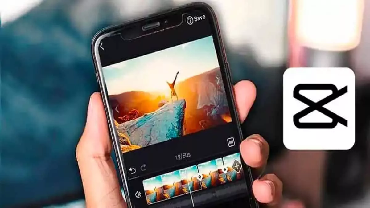 Seseorang memegang smartphone yang menampilkan aplikasi CapCut sedang memproses editing video.