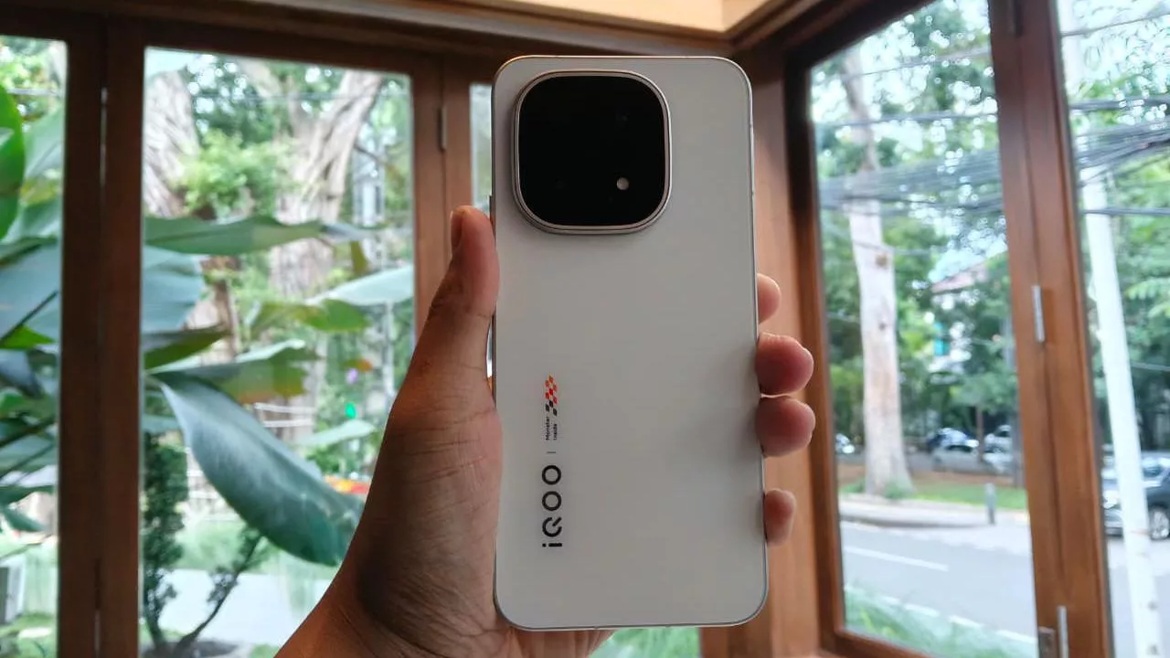 Foto langsung (hands-on) smartphone iQOO 15 Ultra varian warna putih yang digenggam dengan latar belakang jendela.