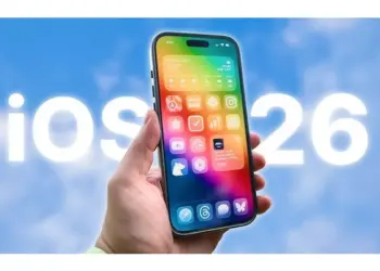 Tampilan antarmuka iOS 26 pada smartphone yang menunjukkan desain wallpaper sistem operasi terbaru.