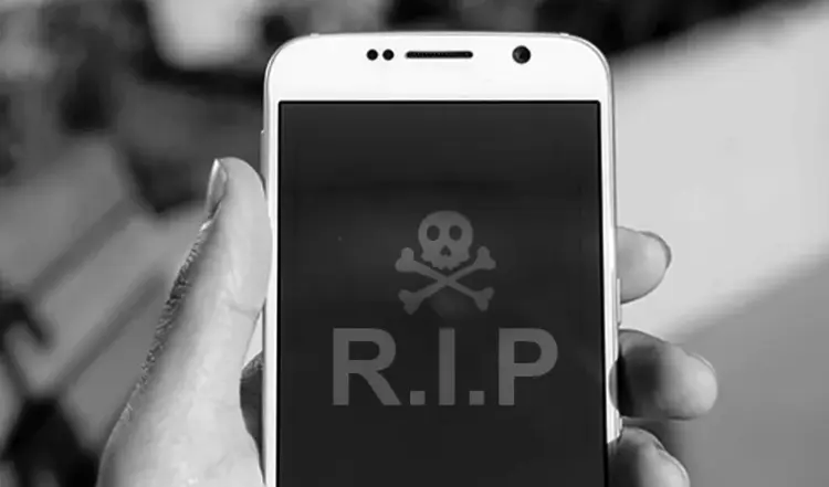 Layar smartphone menampilkan simbol tengkorak dan tulisan RIP sebagai ilustrasi HP mati total.