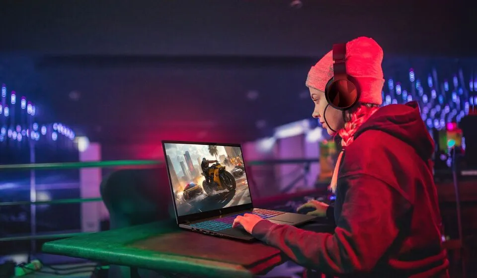 Gamer wanita menggunakan laptop gaming Acer Nitro V 16S AI yang tipis dengan ketebalan 17,9 mm dan dukungan prosesor Intel Core Ultra 7 355.