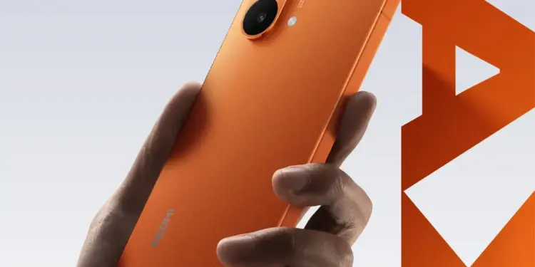 Smartphone Redmi Turbo 5 Max berwarna oranye cerah, menampilkan desain belakang dengan dua kamera besar dan logo Redmi, varian warna mirip iPhone dengan baterai 9000mAh.