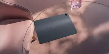 Tampilan bodi belakang OPPO Pad 5 Matte Display Edition berwarna abu-abu gelap yang elegan di atas meja kaca.