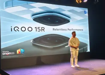 Suasana peluncuran resmi iQOO 15R di atas panggung dengan layar besar bertuliskan "Relentless Performance" dan logo OriginOS.