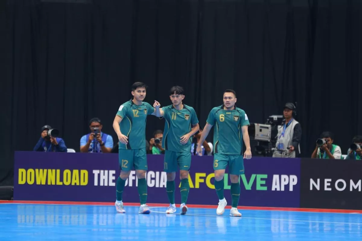 Tiga pemain Timnas Indonesia dengan jersey hijau berjalan di lapangan saat pertandingan Piala Asia Futsal.