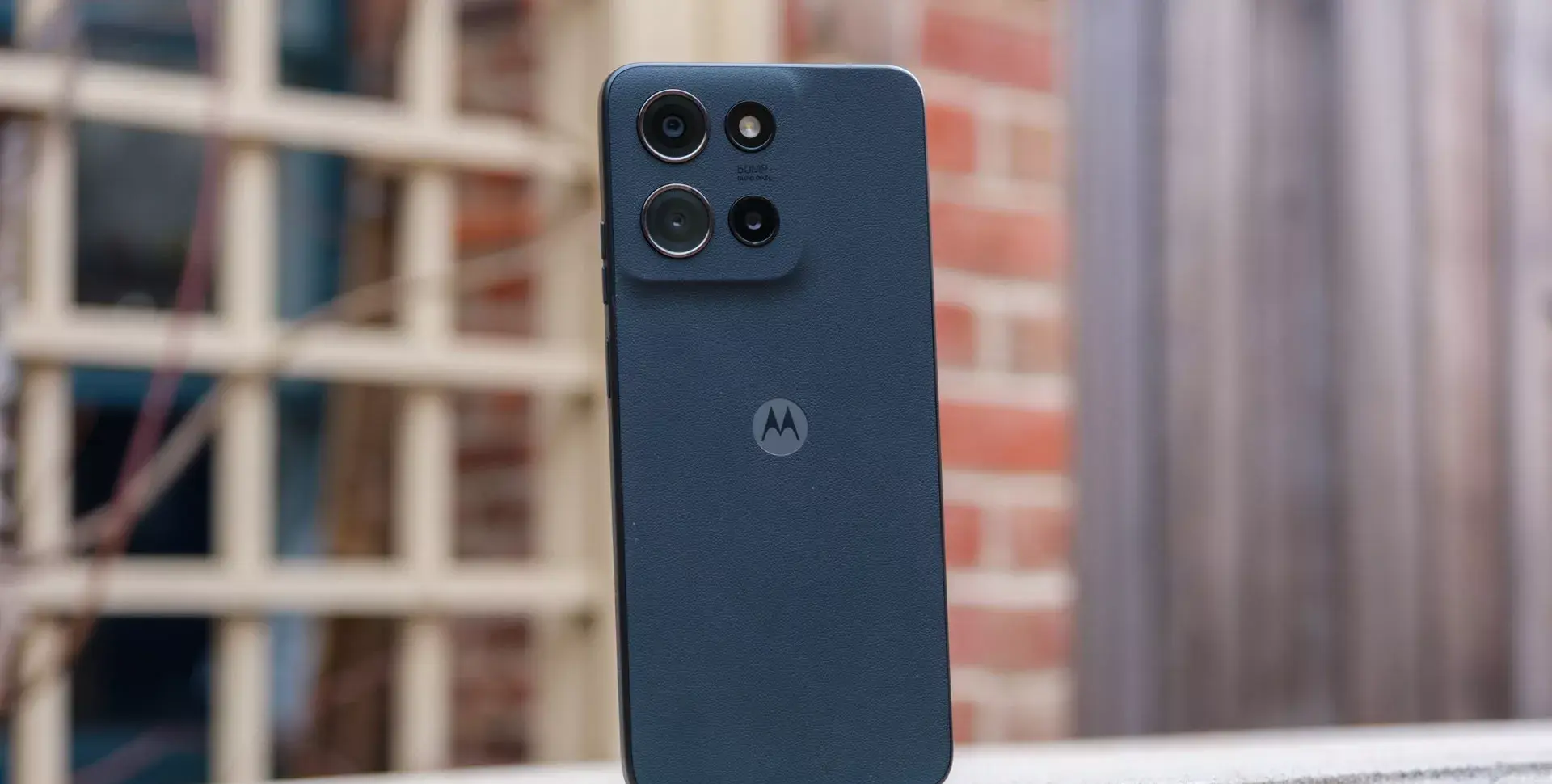 Bagian belakang smartphone Motorola Edge 50 Pro dengan tekstur kulit sintetis biru tua.