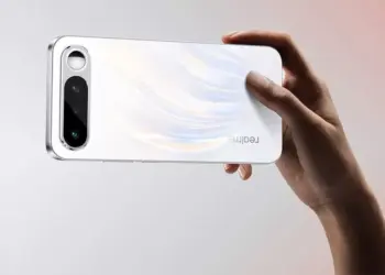 Seseorang sedang memegang smartphone Realme 16 secara horizontal menunjukkan tekstur bodi belakang yang berkilau.