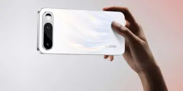 Seseorang sedang memegang smartphone Realme 16 secara horizontal menunjukkan tekstur bodi belakang yang berkilau.