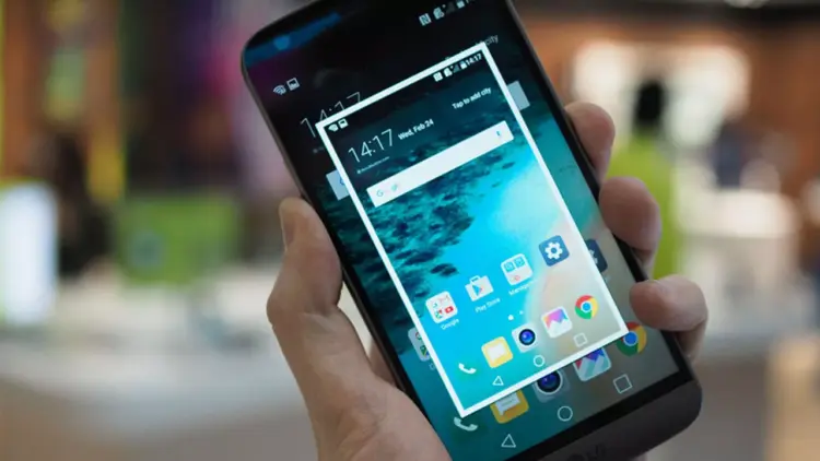 Proses pengambilan tangkapan layar pada layar utama smartphone sebagai langkah awal tutorial cara screenshot panjang.