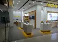 Suasana di dalam gerai resmi Realme Store yang menampilkan berbagai model ponsel di atas meja display.