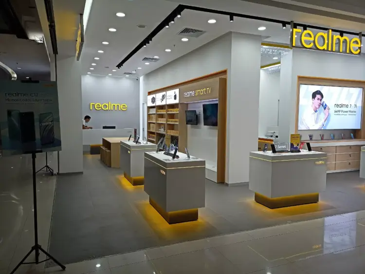 Suasana di dalam gerai resmi Realme Store yang menampilkan berbagai model ponsel di atas meja display.