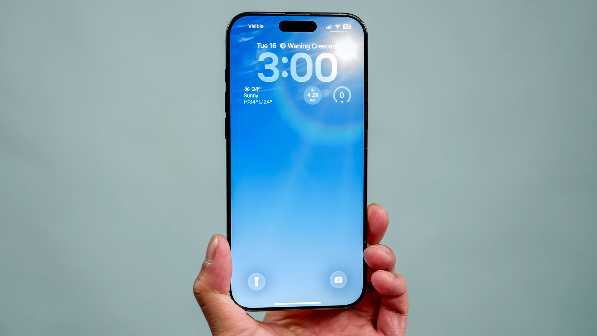 Seseorang memegang iPhone yang sudah menjalankan sistem operasi iOS 26.3.