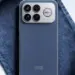 Tampilan close-up panel belakang Redmi K90 Ultra berwarna biru denim, menonjolkan modul kamera besar dengan empat lensa dan grill kipas pendingin aktif berwarna perak, sebagian tertutup kain biru.