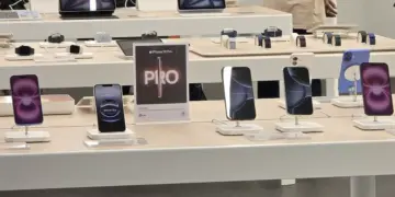 Alt Text (Teks Alternatif): Deretan iPhone 15 dan iPhone 16 dipajang di atas meja display putih di dalam toko iBox Indonesia dengan tanda promosi iPhone 16 Pro.