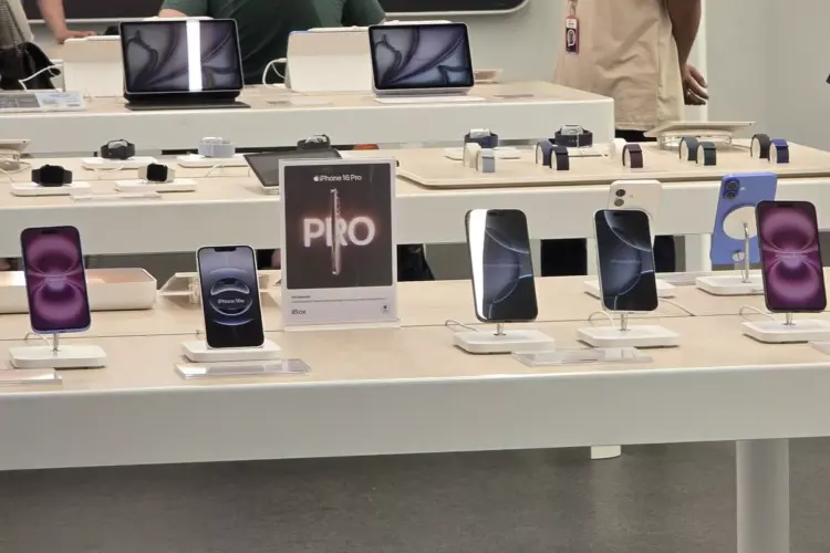 Alt Text (Teks Alternatif): Deretan iPhone 15 dan iPhone 16 dipajang di atas meja display putih di dalam toko iBox Indonesia dengan tanda promosi iPhone 16 Pro.