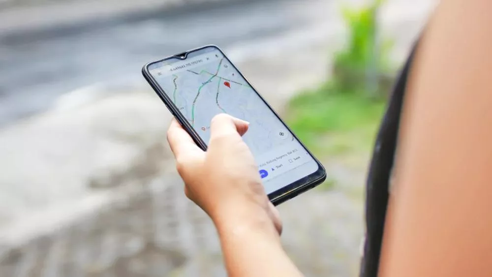 Pengguna sedang memantau pergerakan lokasi pasangan secara mobile menggunakan Google Maps di HP terbaru.
