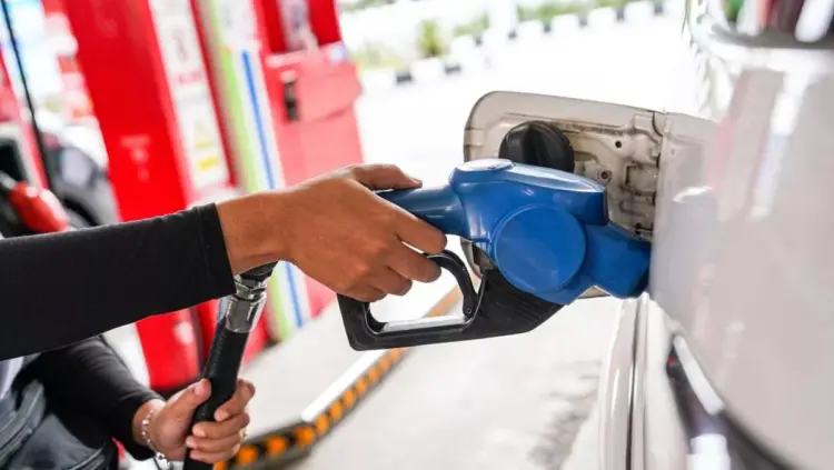 Petugas SPBU memasukkan nozzle pengisian BBM ke tangki mobil, ilustrasi kenaikan harga Pertamax dan jenis BBM lainnya.