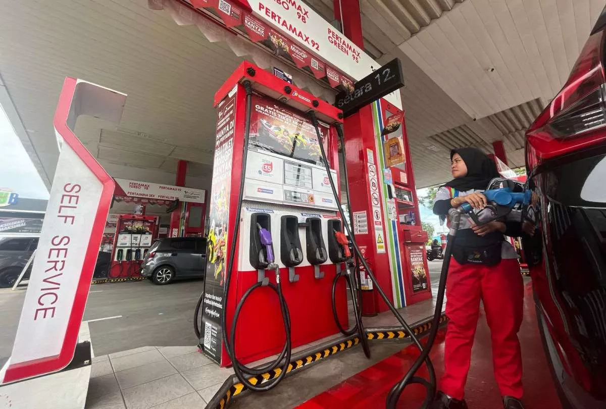 Petugas wanita di SPBU Pertamina melayani pengisian BBM di area Self Service dekat mesin pompa Pertamax Turbo dan Dex.