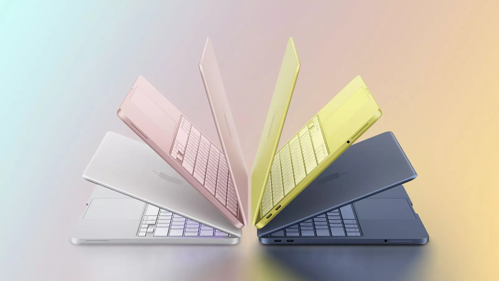 Jajaran varian warna MacBook Neo yang variatif, mulai dari silver, pink, kuning, hingga biru tua dalam posisi terbuka membentuk pola kipas.