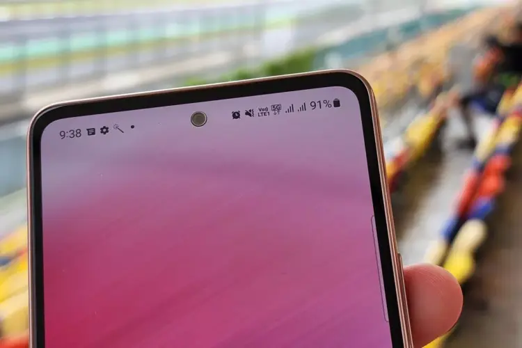 Indikator sinyal 5G dan VoLTE pada status bar HP Android di area terbuka atau stadion.
