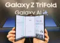 Seseorang sedang memegang perangkat Samsung Galaxy Z TriFold dengan tiga lipatan layar yang menampilkan antarmuka Google dan Galaxy AI.