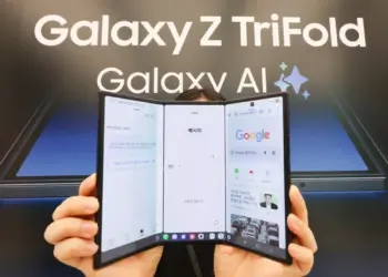 Seseorang sedang memegang perangkat Samsung Galaxy Z TriFold dengan tiga lipatan layar yang menampilkan antarmuka Google dan Galaxy AI.