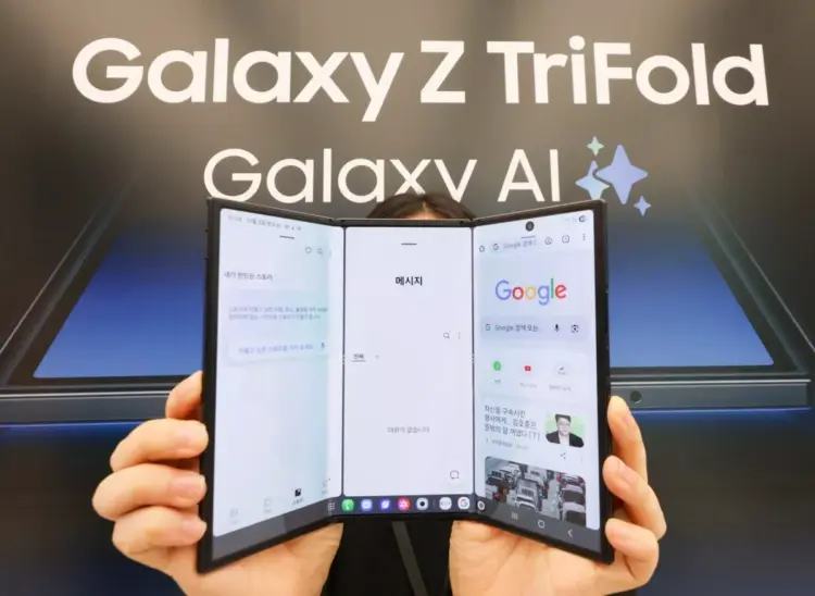 Seseorang sedang memegang perangkat Samsung Galaxy Z TriFold dengan tiga lipatan layar yang menampilkan antarmuka Google dan Galaxy AI.