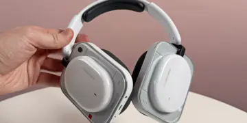 Seseorang sedang memegang Nothing Headphone (a) varian warna putih yang memiliki desain earcup transparan yang ikonik.