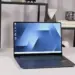 Tampilan layar AMOLED laptop Samsung Galaxy Book 6 dengan wallpaper biru minimalis di atas meja.