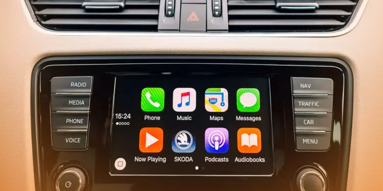 Tampilan antarmuka Apple CarPlay pada layar dashboard mobil yang menunjukkan ikon aplikasi musik gratis dan navigasi.