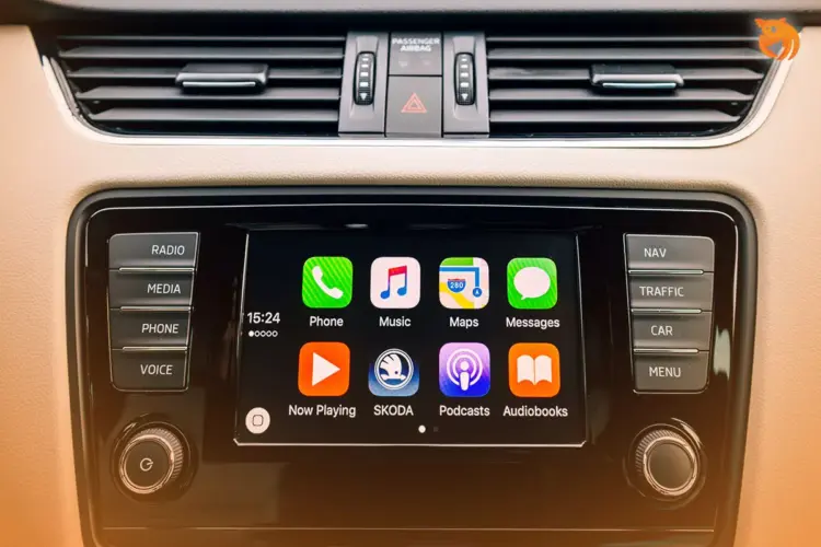 Tampilan antarmuka Apple CarPlay pada layar dashboard mobil yang menunjukkan ikon aplikasi musik gratis dan navigasi.
