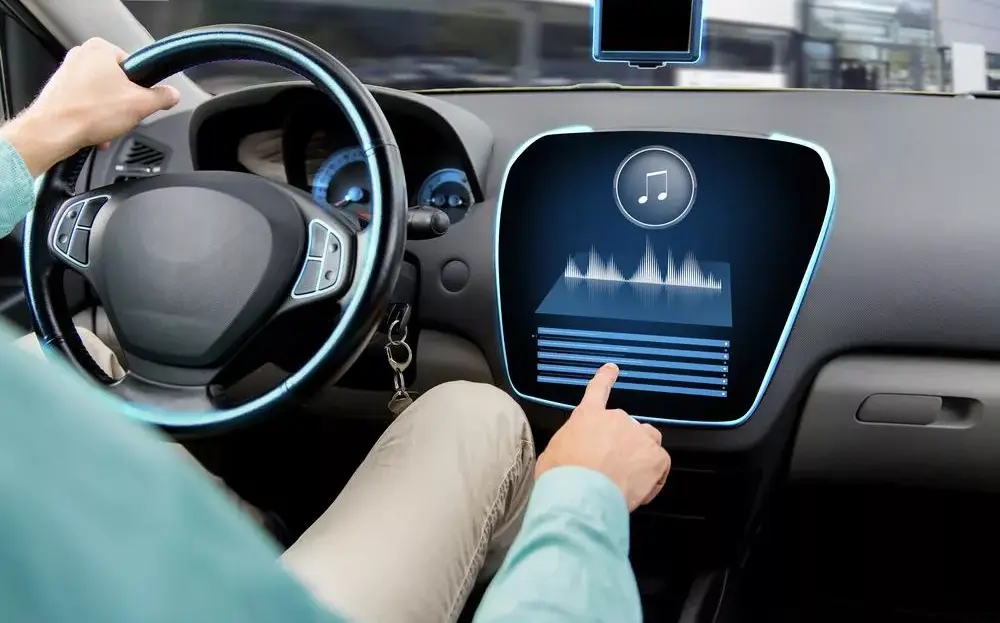 Ilustrasi pengemudi mobil menggunakan layar sentuh canggih untuk memutar audio visualizer dari aplikasi musik gratis.