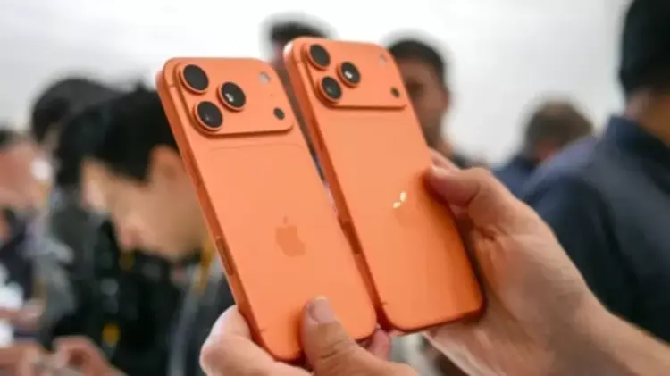 Dua unit iPhone 17 dengan desain modul kamera baru berwarna oranye copper yang elegan.