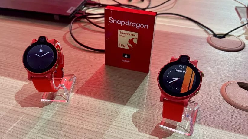 Dua unit smartwatch prototipe berwarna merah yang ditenagai oleh Snapdragon Wear Elite dipamerkan di atas meja kayu pada ajang MWC 2026.