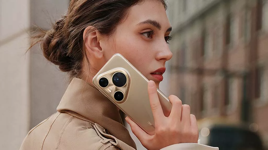 Seorang wanita dengan mantel cokelat memegang Huawei Pura 90 Pro warna emas di dekat telinganya dengan latar belakang kota yang buram.