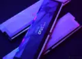 Tiga keping RAM DDR5 merk Crucial dengan pencahayaan neon ungu kebiruan.