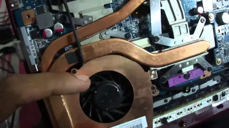 Komponen heatsink tembaga dan kipas laptop yang terpasang di dalam casing.