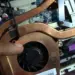 Komponen heatsink tembaga dan kipas laptop yang terpasang di dalam casing.